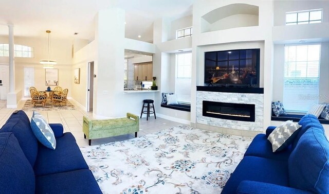 tiled living room featuring a stone fireplace