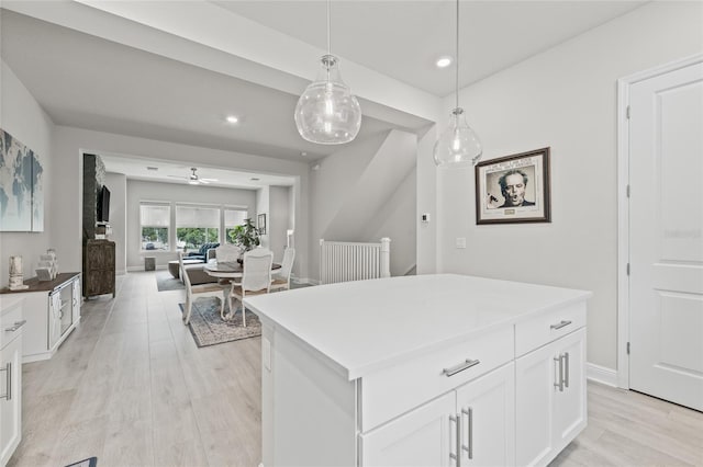 kitchen featuring pendant lighting, light wood finished floors, white cabinetry, a center island, and recessed lighting