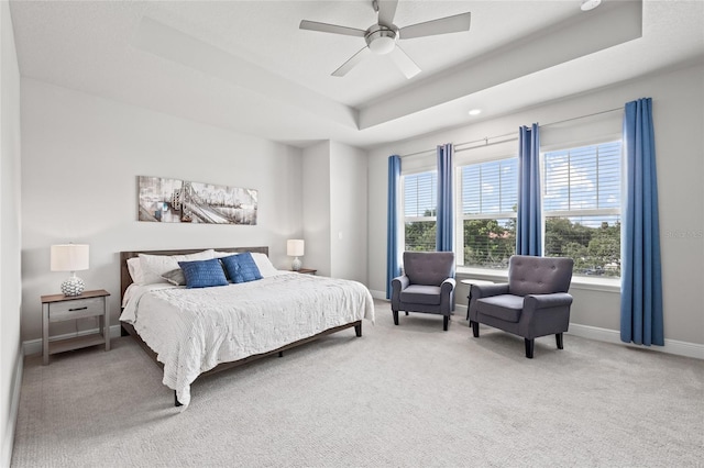 bedroom featuring baseboards, multiple windows, carpet, and a raised ceiling