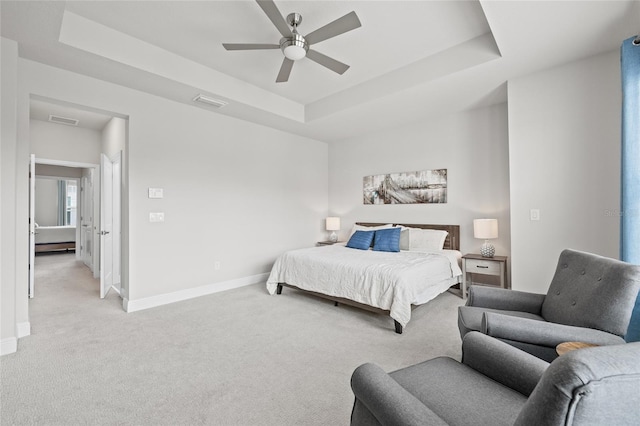 bedroom featuring baseboards, visible vents, light carpet, and a raised ceiling