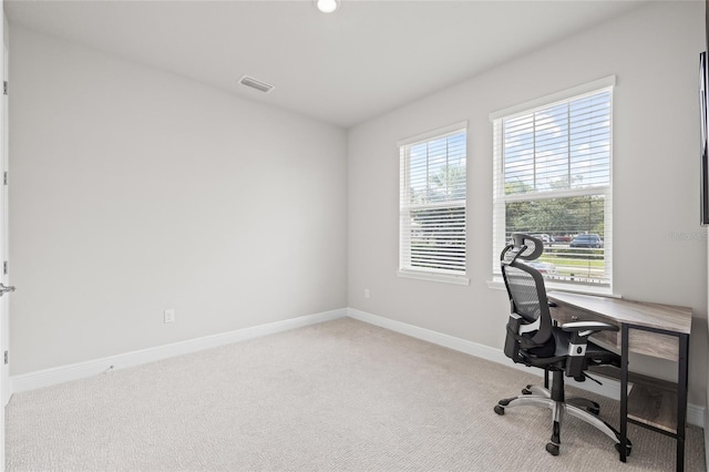 carpeted office space with baseboards and visible vents