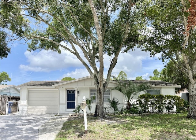 ranch-style house with brick siding, an attached garage, driveway, and fence