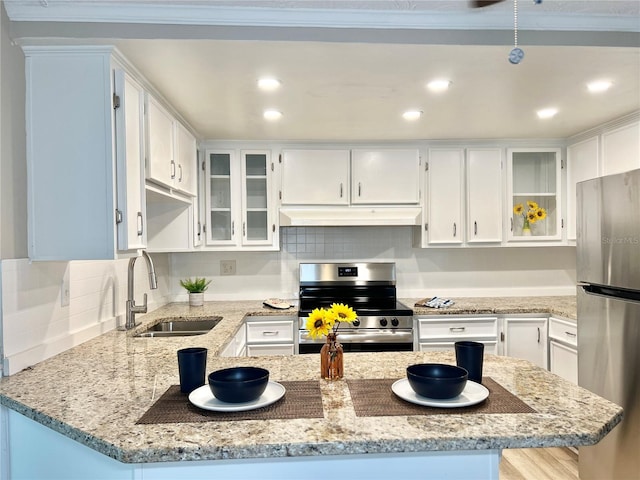 kitchen featuring white cabinets, appliances with stainless steel finishes, sink, and light stone countertops