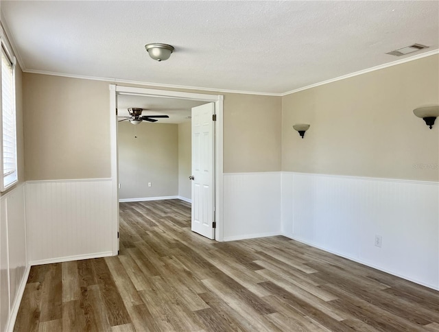 spare room featuring crown molding, a textured ceiling, hardwood / wood-style floors, and ceiling fan