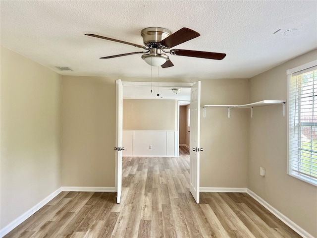 unfurnished room featuring plenty of natural light, ceiling fan, and light hardwood / wood-style floors