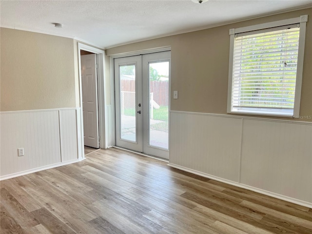 doorway to outside with french doors, a healthy amount of sunlight, and light hardwood / wood-style floors