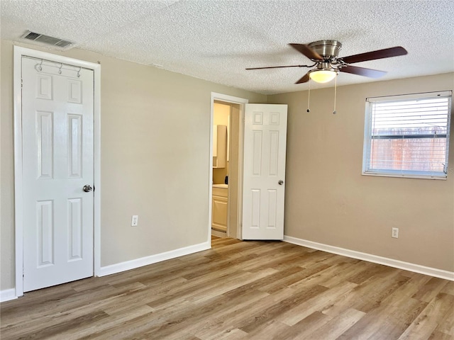 unfurnished bedroom with a textured ceiling, ceiling fan, and hardwood / wood-style floors