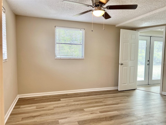 unfurnished room featuring light hardwood / wood-style flooring, ceiling fan, and french doors