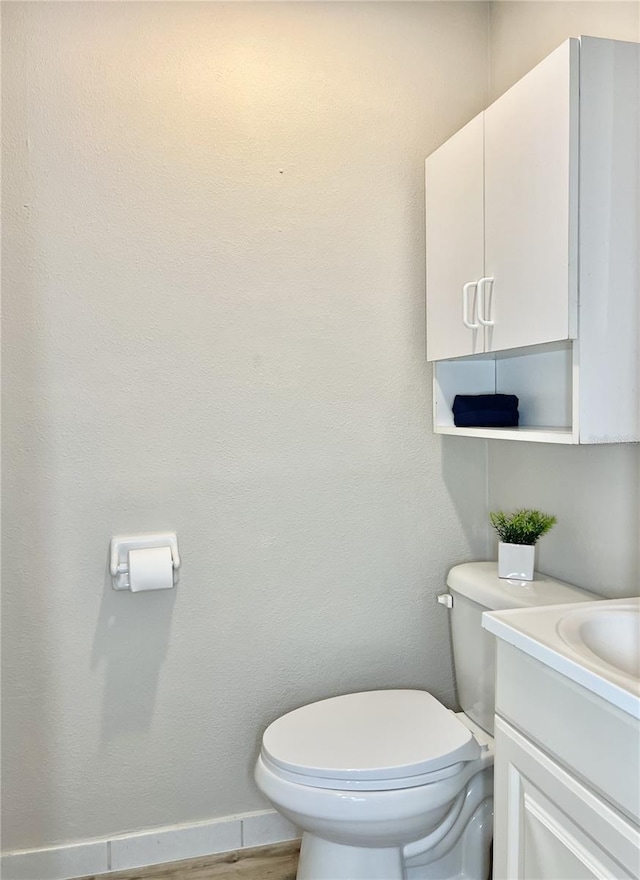 bathroom featuring vanity, toilet, and hardwood / wood-style flooring