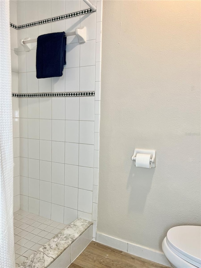 bathroom featuring toilet, wood-type flooring, and curtained shower