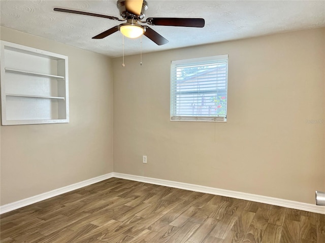 empty room featuring a textured ceiling, hardwood / wood-style flooring, and ceiling fan