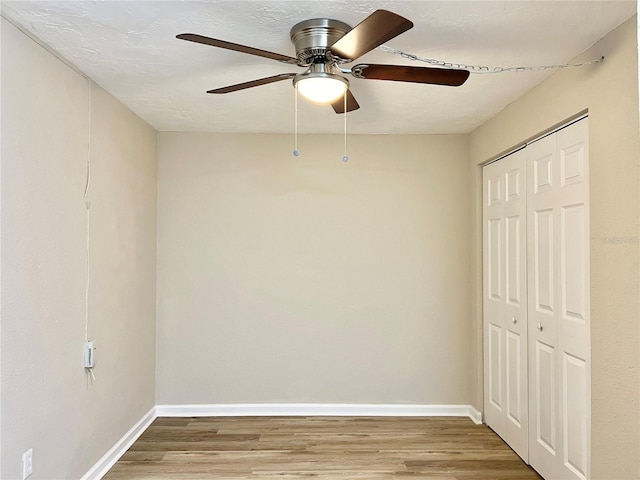 interior space with a textured ceiling, hardwood / wood-style flooring, ceiling fan, and a closet