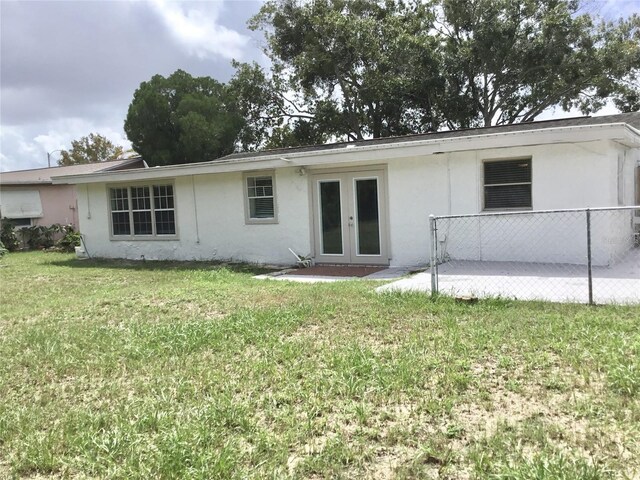 rear view of house with a lawn and french doors