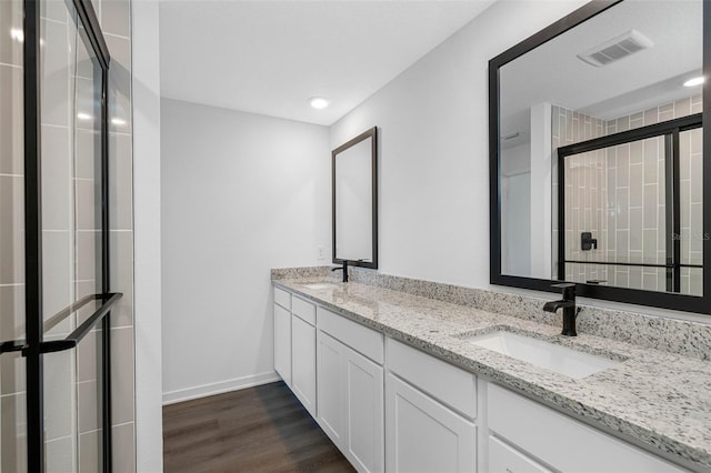 bathroom featuring wood-type flooring, an enclosed shower, and vanity