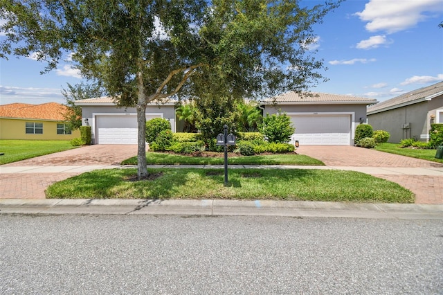 view of front of home with a garage and a front lawn