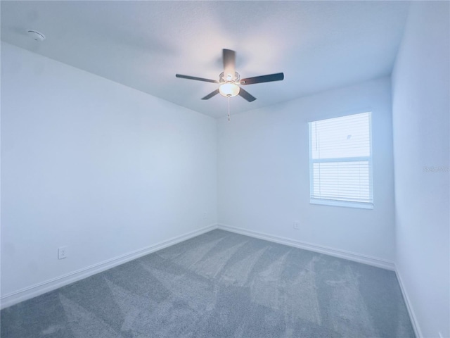 empty room with dark carpet and ceiling fan