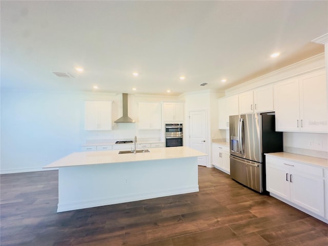 kitchen featuring an island with sink, white cabinets, wall chimney exhaust hood, stainless steel appliances, and dark hardwood / wood-style flooring