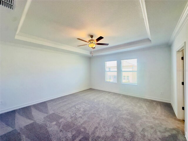 carpeted empty room with a textured ceiling, a raised ceiling, ornamental molding, and ceiling fan