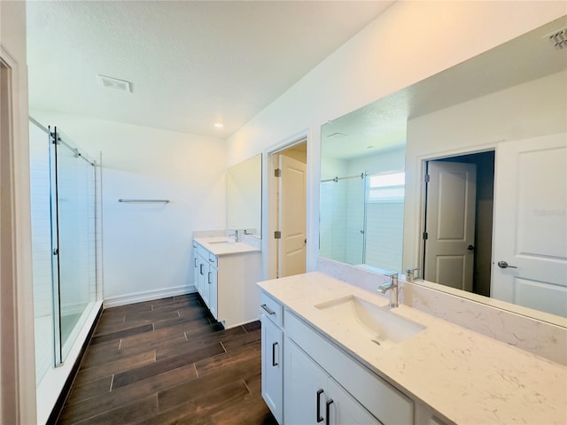 bathroom featuring walk in shower, wood-type flooring, and vanity