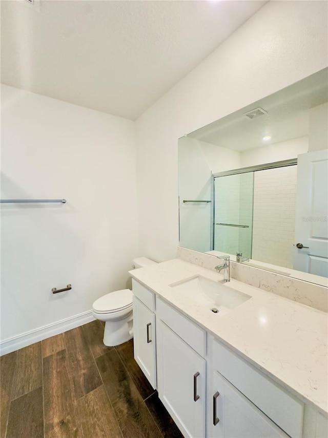 bathroom featuring vanity, toilet, an enclosed shower, and hardwood / wood-style flooring