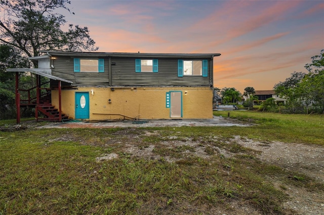 back house at dusk with a yard