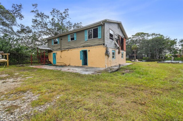 rear view of house featuring a lawn and a patio area