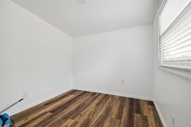 unfurnished room with dark wood-type flooring and baseboards