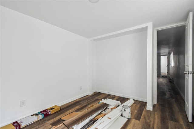 empty room with dark hardwood / wood-style flooring