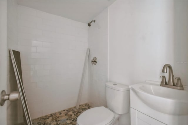 bathroom with a stall shower, toilet, and vanity