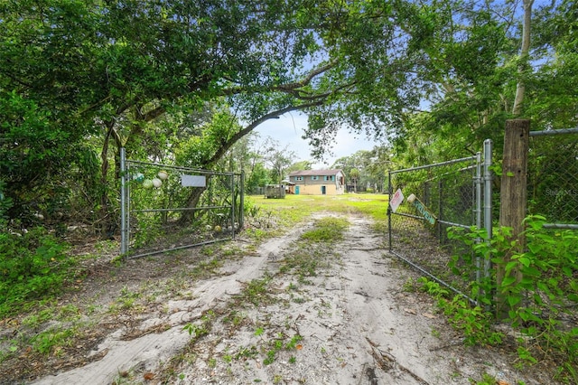 view of road with a gated entry, dirt driveway, and a gate