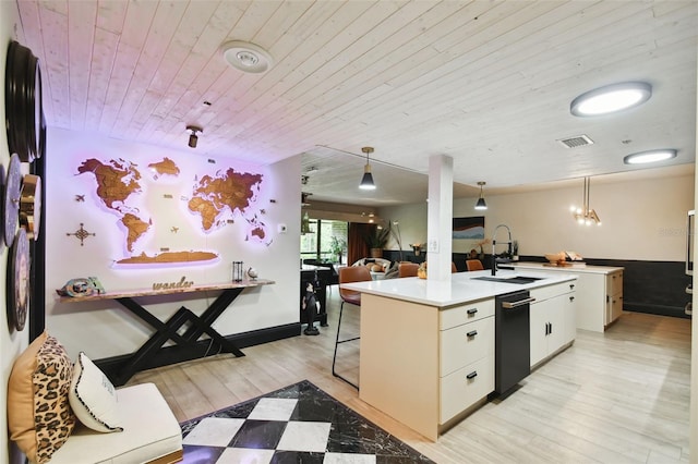 kitchen with pendant lighting, sink, white cabinets, and light hardwood / wood-style floors