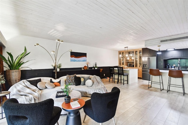 living room featuring wood ceiling, an inviting chandelier, and light hardwood / wood-style floors