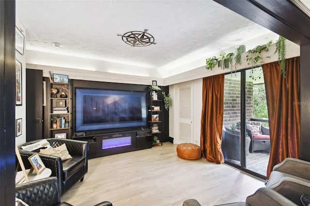 living room featuring light wood-type flooring and a textured ceiling