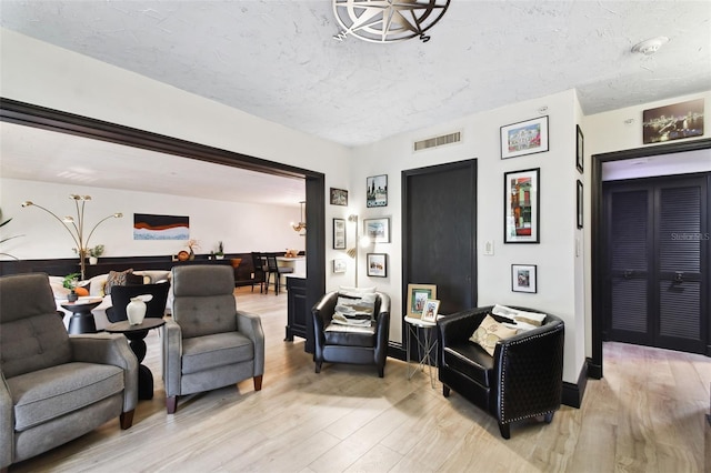 living room featuring a textured ceiling and light hardwood / wood-style flooring