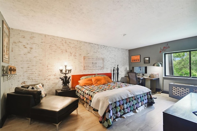 bedroom featuring a textured ceiling and light hardwood / wood-style floors