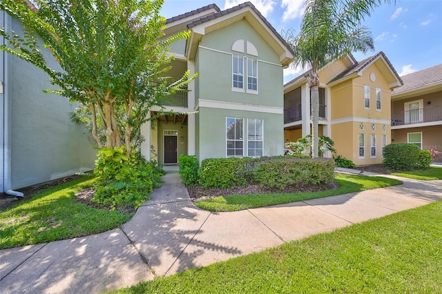 view of front of property with a balcony and a front yard