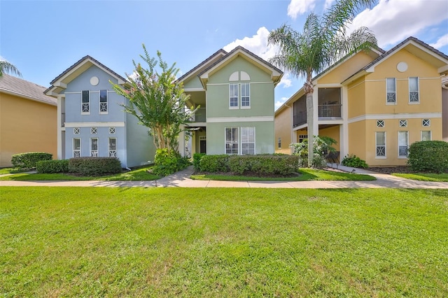 view of front of property featuring a balcony and a front yard