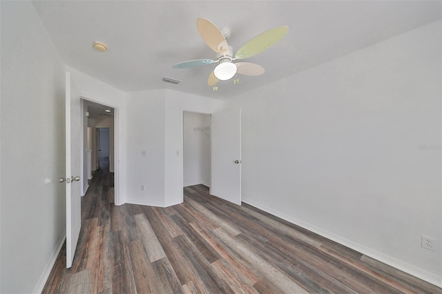 unfurnished bedroom featuring dark hardwood / wood-style flooring, ceiling fan, and a closet