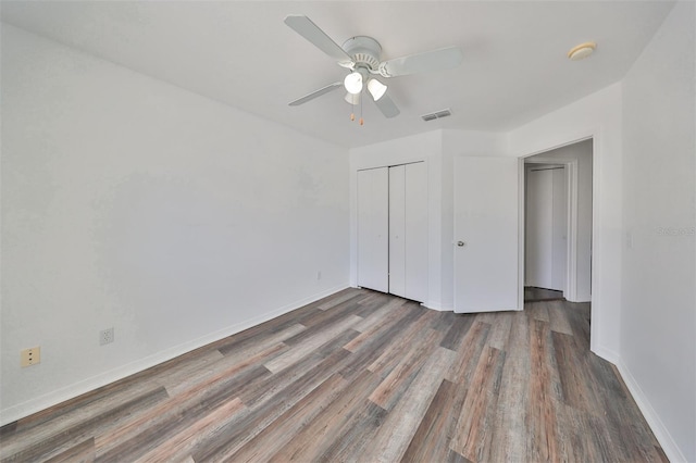 unfurnished bedroom with a closet, ceiling fan, and wood-type flooring