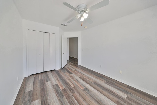 unfurnished bedroom with hardwood / wood-style flooring, ceiling fan, and a closet