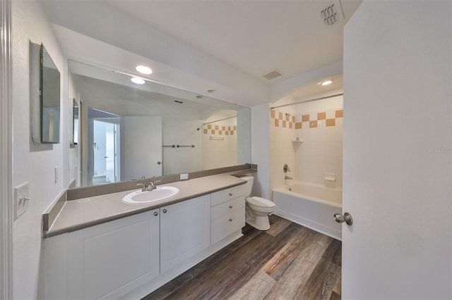 full bathroom with vanity, toilet, hardwood / wood-style flooring, and tiled shower / bath