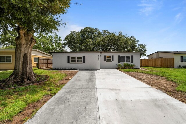 single story home featuring a front lawn