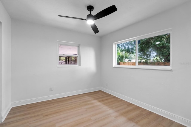 unfurnished room with a healthy amount of sunlight, hardwood / wood-style floors, and ceiling fan