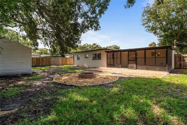 view of yard with a sunroom and an outdoor fire pit