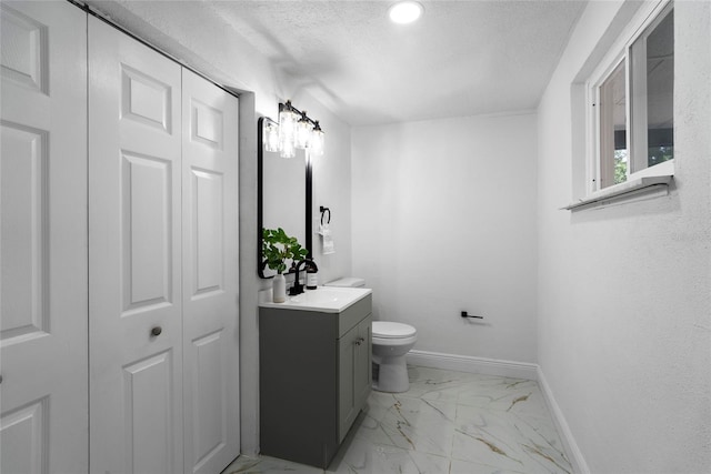 bathroom featuring toilet, a textured ceiling, and vanity