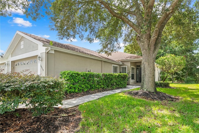 single story home featuring a front lawn and a garage