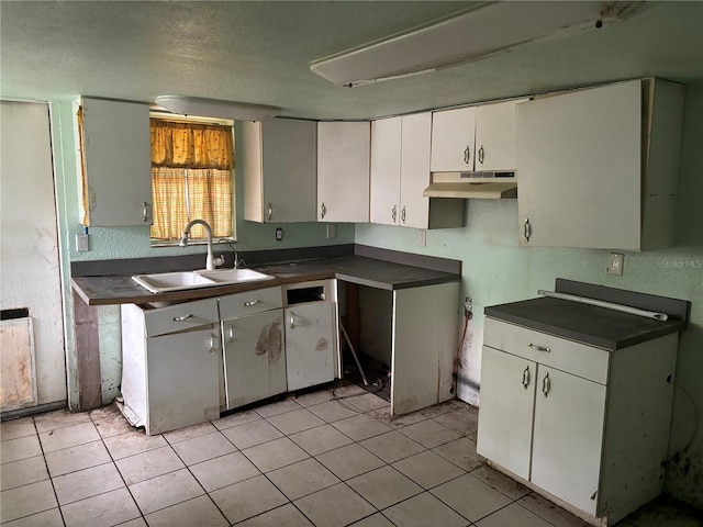 kitchen featuring white cabinets, light tile patterned floors, a textured ceiling, and sink