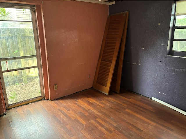 spare room with a wealth of natural light and hardwood / wood-style floors