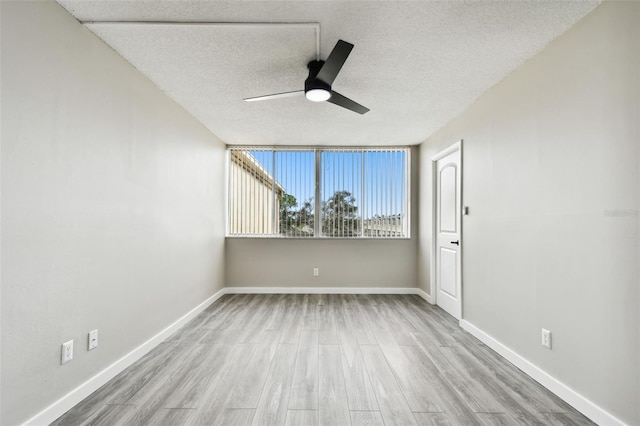 empty room featuring a textured ceiling, ceiling fan, and light wood-type flooring