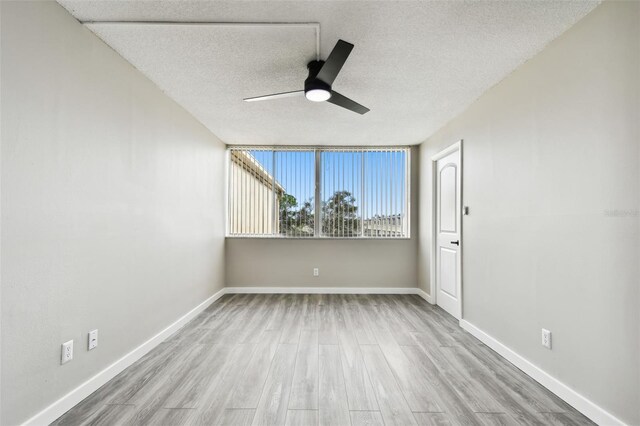 5095 Bay St NE Unit 306, Saint Petersburg, FL 33703 - unfurnished room with baseboards, ceiling fan, a textured ceiling, and wood finished floors